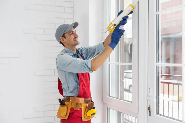 O trabalhador instalando e verificando janela na casa — Fotografia de Stock