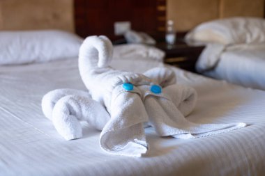 Bir otel odasındaki yataktaki havlulardan yapılmış akrep heykelciği..