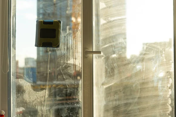 대낮에 아주 더럽고 먼지많은 유리로 창문을 두드린다. 청소 로봇 — 스톡 사진