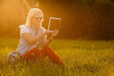 genç kızla mutlu: dijital tablet çim parkta oturan