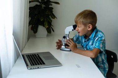 Uzaktan öğrenme çevrimiçi eğitim. Bir okul çocuğu evde ders çalışır ve okul ödevi yapar. Evden öğrenme