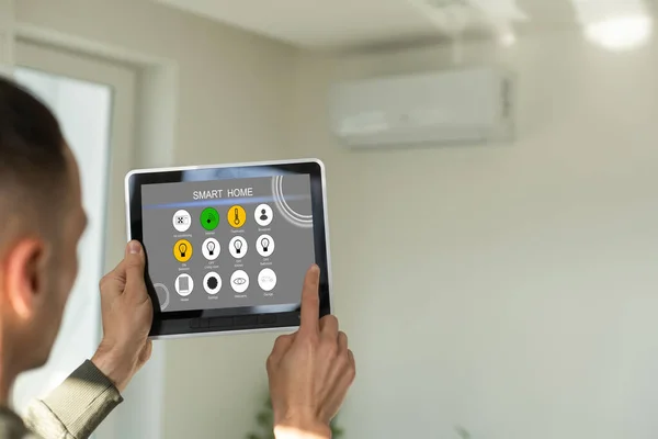 Manipulating air conditioner with tablet — Stock Photo, Image