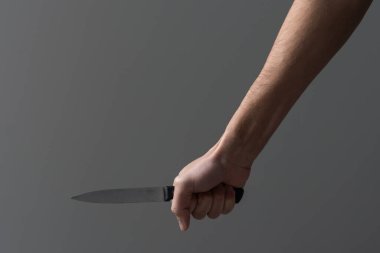 An aggressive man attacks with a knife. Stabbing attack. Hand with a knife. Murder with a knife. clipart