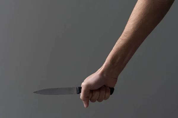 An aggressive man attacks with a knife. Stabbing attack. Hand with a knife. Murder with a knife.