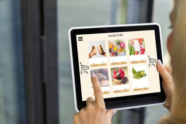 İnternetten yemek sipariş etmek için tablet kullanan kadın eller