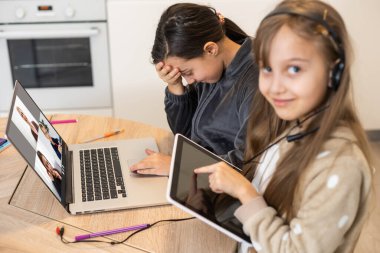 Bağlantı iyi. Seni duyabiliyorum. Küçük kız rahat masa başı çalışma uzaktan bilgisayarla internet üzerinden öğretmenlerle iletişim kurma ev içinde kulaklık var..