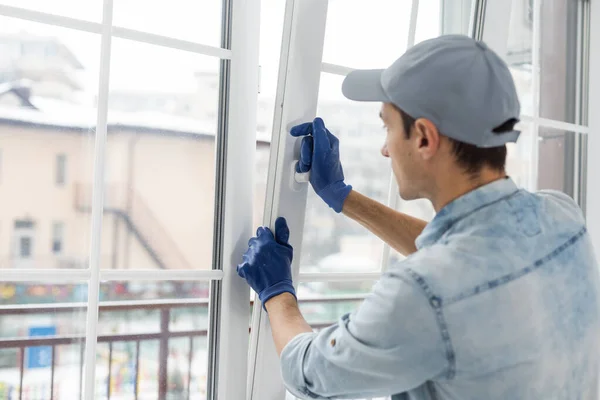 O trabalhador instalando e verificando janela na casa — Fotografia de Stock
