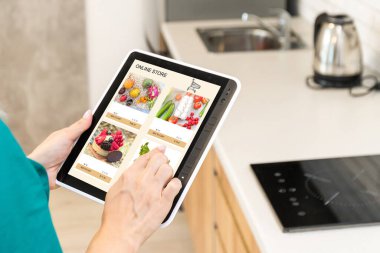 Sayısal Tablet ile Kadın Sahibi Delicatessen Yüz Maskesi Giyiyor Çevrimiçi Bakkal Siparişi.