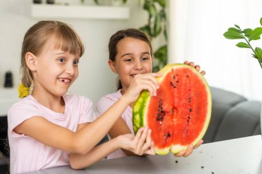 Komik küçük kız evde taze sulu karpuz yeme