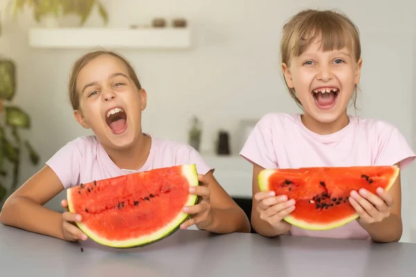 Dwie dziewczyny jedzące arbuza w domu. — Zdjęcie stockowe