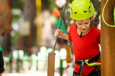 Çocuk tırmanışçı ip köprüde yürüyor,