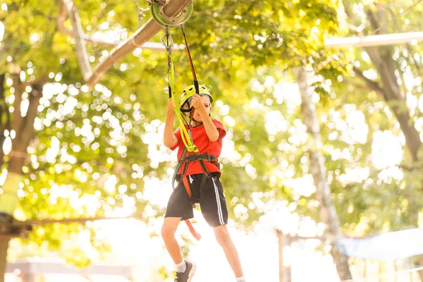 Adventure climbing high wire park - mały chłopiec na kursie w górskim hełmie i sprzęcie bezpieczeństwa — Zdjęcie stockowe