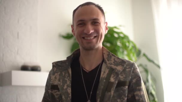 Fotografía cinematográfica de joven feliz soldado sonriente en camuflaje militar uniforme está haciendo videollamada tecnología a su familia o amigos acaba de volver a casa después de la misión. — Vídeos de Stock