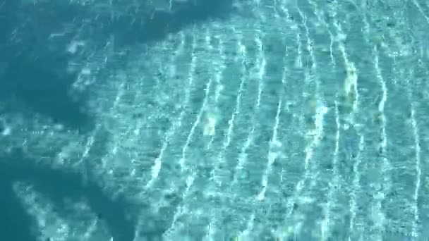 Textura da superfície da água, movimento lento ondas limpas piscina e onda, Refração da luz solar vista superior textura mar lado areia branca, sol brilho fundo de água. Fundo Caustic da água. — Vídeo de Stock