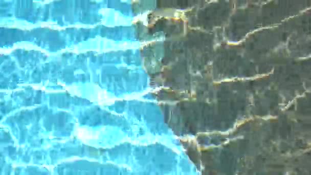 Eau bleue pure dans la piscine avec reflets lumineux au ralenti. Images aériennes. — Video