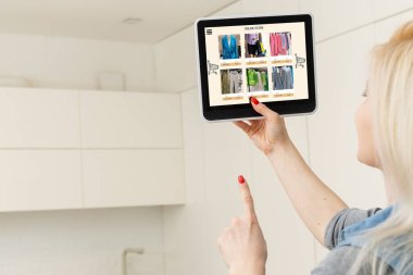 İnternetten kıyafet alan bir kadın. Tablet kullanan kadın