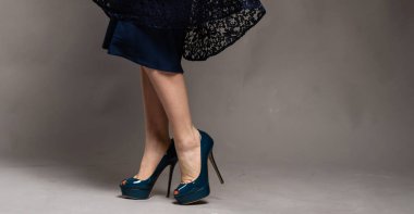 güzel kadın bacaklar etek ve topuklu. Genç kadın ayakta giyen yüksek topuklar