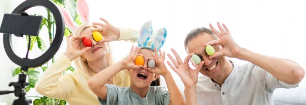 Vater, Mutter und ihr Kind bemalen gerne Ostereier. Online einkaufen für fröhliche Osterdekoration. Ostereier - farbiges Eiersortiment — Stockfoto