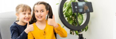 Fotoğrafı kapatın. İki küçük kız selfie çekin, konuşun, konuşun, konuşun.