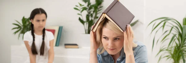 Belle écolière faisant ses devoirs avec sa mère à la maison — Photo