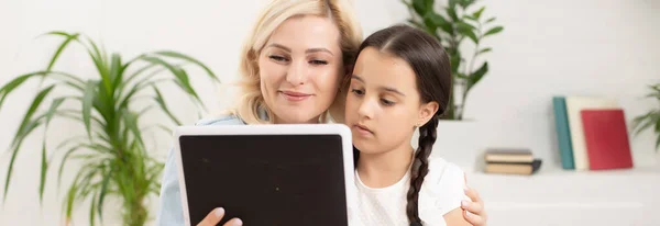Mãe e filha usando tablet digital em casa — Fotografia de Stock