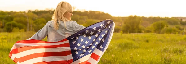 Land, patriotism, självständighetsdag och människor koncept - glad leende ung kvinna med nationell amerikansk flagga på fältet — Stockfoto