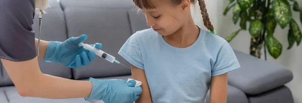 Enfermera que administra la inyección de vacunación a una niña pequeña paciente — Foto de Stock