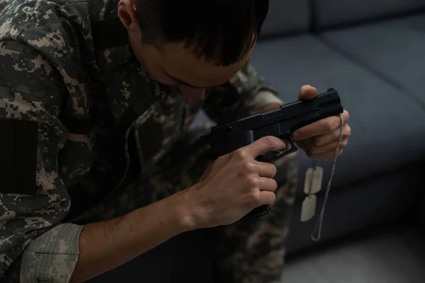 Λυπημένος στρατιώτης κάθεται με ένα όπλο — Φωτογραφία Αρχείου