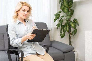 Profesyonel psikoterapi. Başarılı Psikolog Dizini Tutarken, Ofiste Koltukta Otururken.