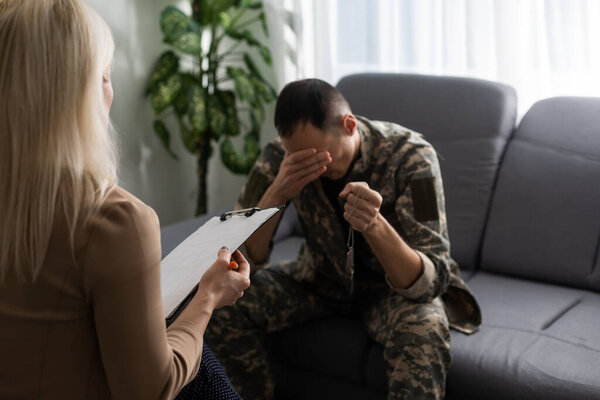 Image of sad soldier having support of his private therapist