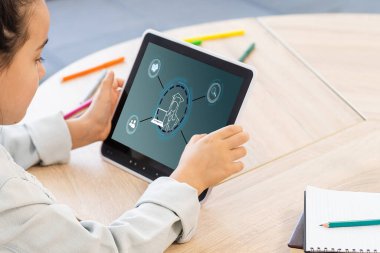 Çevrimiçi eğitim, e-öğrenme ve e-kitap konsepti. Eğitim, eğitim ve çevrimiçi öğrenme medya simgeleriyle dijital tablet kullanan bir adam