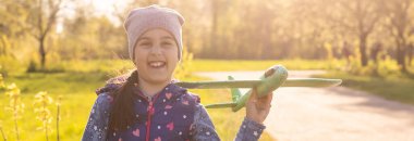 Hızlı koşan ve uçak oyuncağı tutan kız.