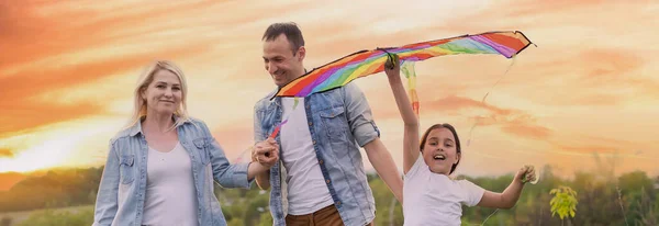 Ayah keluarga bahagia, ibu dan anak perempuan Meluncurkan layang-layang di alam saat matahari terbenam — Stok Foto
