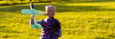 Hızlı koşan ve uçak oyuncağı tutan kız.