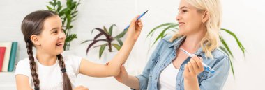 Sevgi dolu bir aile. Anne ve kızı çocuk oyun oynuyor ve ödev yapıyor..