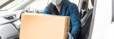 Kargo şoförü koltukta paketler ile araba kullanıyor.