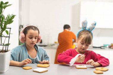 Evde zencefilli kurabiye yapan iki küçük kız..