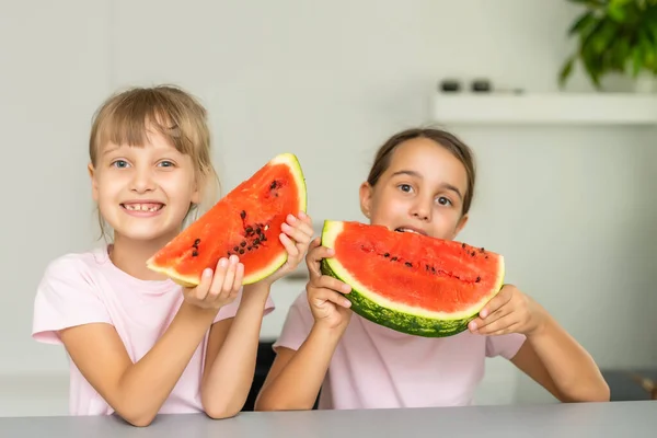 Duas meninas comendo melancia isolada em casa — Fotografia de Stock