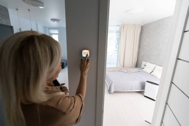 Duvardaki termostat akıllı ev domotik kontrol paneli kışlık ev sıcaklığı panoramik pankartı için. Enerji tasarruflu el dokunuşu oturma odasındaki ısıyı ayarlamak için.