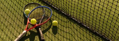 Tenis raketi ve yeni boyanmış tenis kortunda yeni bir tenis topu.