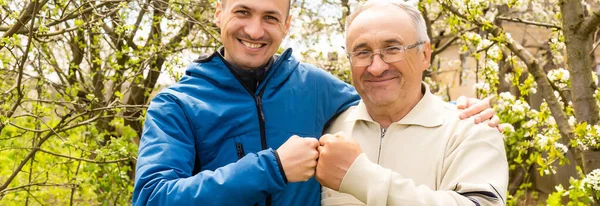 Papà e suo figlio guardano la telecamera in giardino — Foto Stock