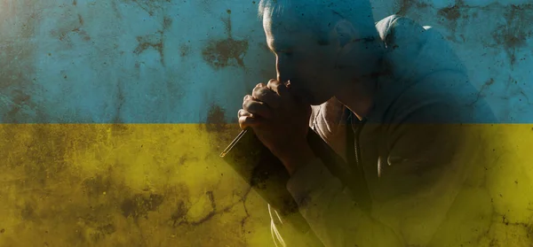 Моліться за Україну. людина молиться за мир, національний прапор — стокове фото