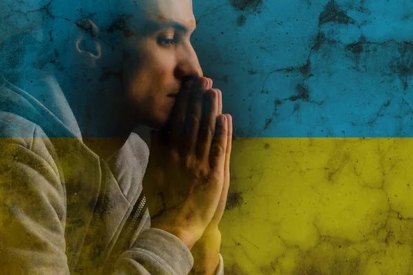 Be för Ukraina. man bön för fred, nationell flagga — Stockfoto