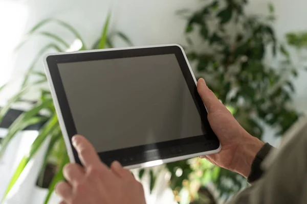 Digitale tablet pc met geïsoleerde scherm in mannelijke handen over café achtergrond — Stockfoto