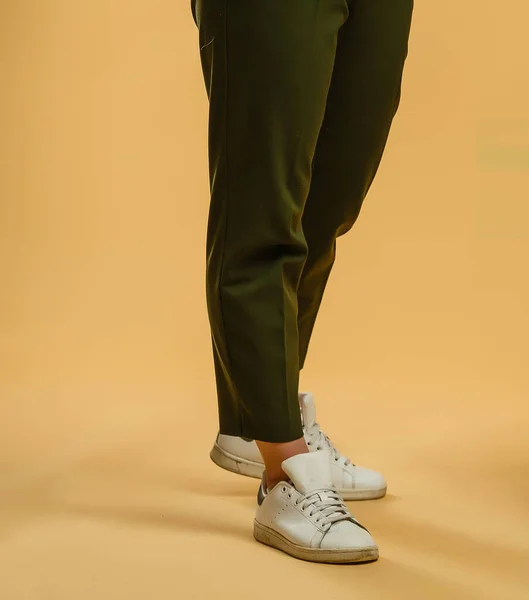 Odwrócone kobiece nogi w lekkich spodniach i tenisówkach — Zdjęcie stockowe