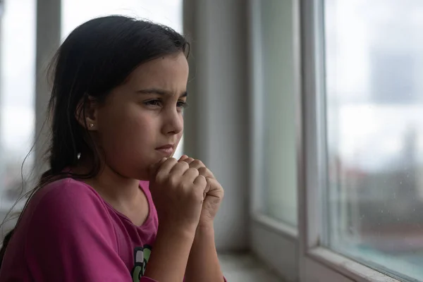 Молитва маленька дівчинка біля вікна — стокове фото