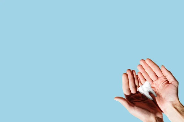 Childs handen houden grote tand en tandenborstel op roze backgroubd. Healty zorg tanden concept. Bovenaanzicht, vlak. Kopieer ruimte voor uw tekst. — Stockfoto