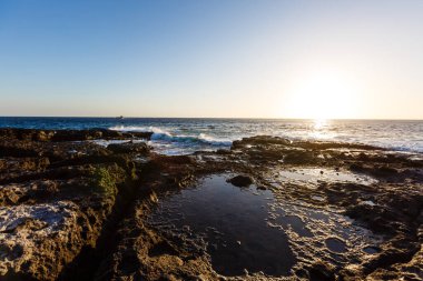 Denizde akşam sahnesi, taşlar, sakin okyanus