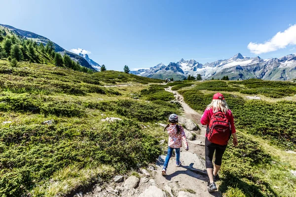 Happy family with little child doing trekking on swit:mountain in summer time. Молодые люди веселятся в ландшафтной природе. Концепция путешествия, дружелюбная семья — стоковое фото