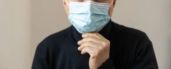 Senior i medicinsk mask isolerad på grå bakgrund. Studio porträtt av vuxen man tittar på kameran Influensa epidemi, damm allergi, skydd mot virus. Covid-19, koronaviruspandemi. — Stockfoto